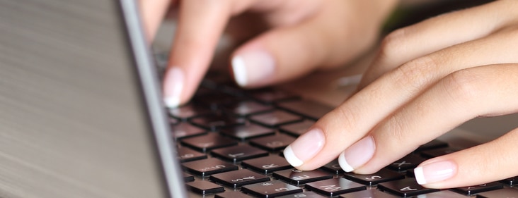 Close up picture of woman typing on laptop