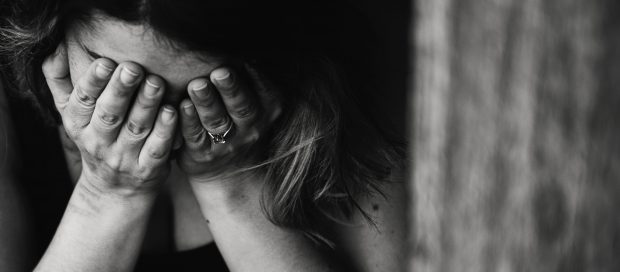 picture of depressed woman holding her hands over face