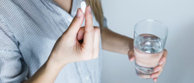 picture of woman taking a pill